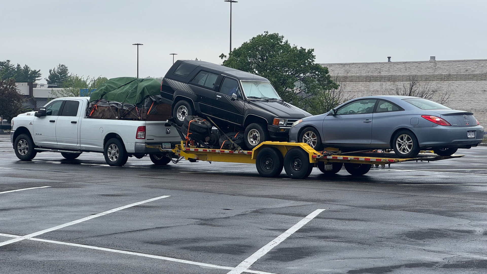 Hauling Patriots white Ram pickup towing a long flatbed trailer loaded with a Toyota 4Runner and a Toyota Solara on a Nashville-area vehicle haul